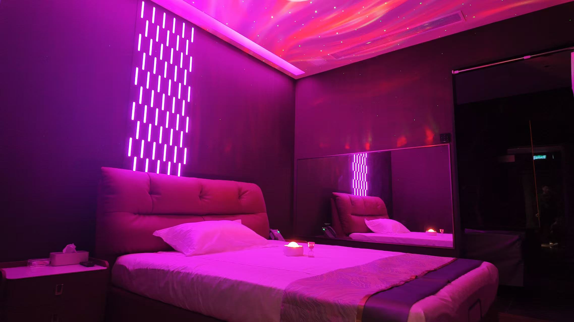 Romantic themed room with pink-purple lighting and starry ceiling